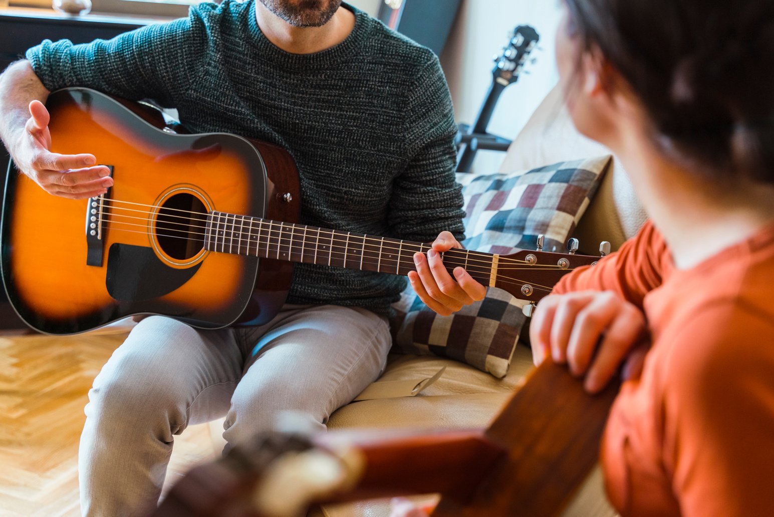 Guitar Teacher Explaining a Music Class to Female Student